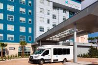 奥兰多Hyatt House Orlando Airport的停在大楼前的白色巴士