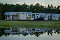 格尔夫海岸Gulf Shores RV Resort的一排移动房屋,靠近一排水体
