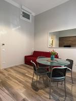 米兰Fiori 3 Apartment的客厅配有红色的沙发、桌子和椅子