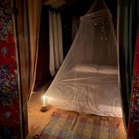 帕拉蒂Cabana Vila do Teteco - Praia do Sono的帐篷内的一张小床,配有一张烛光蜡烛