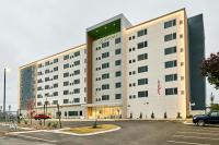 查塔努加Element Chattanooga East的一座白色的大建筑,停车场有停车位