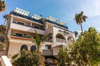 赫尔采格诺维Hotel Vila Hedonija的一座前面有棕榈树的建筑