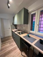 米兰Fiori 3 Apartment的厨房配有绿色橱柜、水槽和柜台。