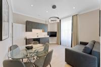 伦敦Cleveland Residences Paddington的带玻璃桌和椅子的客厅