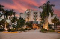 迈阿密Miccosukee Casino &amp; Resort的一条白色的大建筑,在街上种有棕榈树