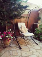 SpartýlasLorantina Luxury Sea View Holiday House close to Barbati &amp; Ipsos Beach with Starlink WiFi的摆满鲜花的露台上的摇椅