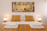 斯普利特Modern 2-Bed Apt, Late check in available的一张带黄色和白色枕头的床和绘画