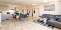 斯普利特Modern 2-Bed Apt, Late check in available的客厅以及带沙发和桌子的厨房。