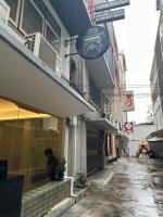 曼谷Dreamcatcher Bangkok的坐在商店窗户上的男人