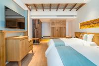张家界Yoba Boutique Hotel的有两张床和一台电视的酒店房间