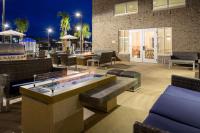 默特尔比奇Homewood Suites By Hilton Myrtle Beach Coastal Grand Mall的庭院设有热水浴池和桌椅。