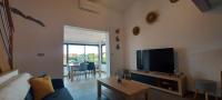 乐巴凯尔斯location maison de vacances jusqu&#39;à 6 personnes près du port et de la plage的带电视、沙发和桌子的客厅
