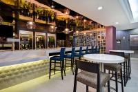皇后区Hampton Inn NY-JFK的一家带酒吧的餐厅，配有蓝色的椅子和桌子