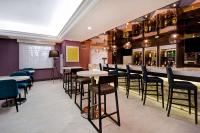 皇后区Hampton Inn NY-JFK的有桌椅和酒吧的餐厅