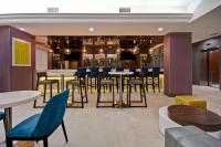 皇后区Hampton Inn NY-JFK的有桌椅和酒吧的餐厅