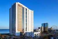 默特尔比奇Hilton Grand Vacations Club Ocean Enclave Myrtle Beach的大海和城市前方的高楼