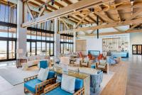 格尔夫海岸The Lodge at Gulf State Park, A Hilton Hotel的客厅配有许多家具和窗户。