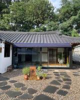 江陵市Bow Hanok House的紫色屋顶和一些植物的房子
