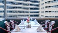 伊斯坦布尔非诺亚酒店的一张桌子,上面摆放着椅子、白色餐巾和鲜花