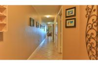 德斯坦Beach Resort 507 - Great Views Beautiful Decor Zero Entry Pool的走廊上设有橙色墙壁,走廊上设有绘画作品
