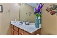 德斯坦Beach Resort 507 - Great Views Beautiful Decor Zero Entry Pool的浴室设有水槽和花卉花瓶。