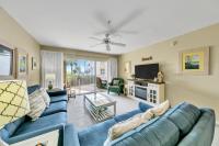 德斯坦Amalfi Coast 113B - Steps from the Beach 2BD 2BA的客厅里有一张蓝色沙发和一台电视