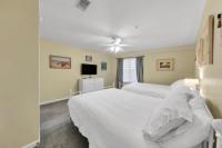 德斯坦Amalfi Coast 113B - Steps from the Beach 2BD 2BA的一间卧室，配有两张床和一台平板电视