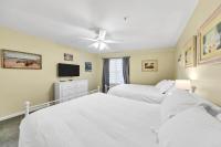 德斯坦Amalfi Coast 113B - Steps from the Beach 2BD 2BA的一间卧室，配有两张床和一台平板电视