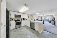 德斯坦Amalfi Coast 113B - Steps from the Beach 2BD 2BA的一间带白色橱柜和电器的厨房和一间客厅