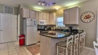 德斯坦Biglows Bungalow - About a quarter mile to PRIVATE Neighborhood Beach Access, Pet Friendly, Community Pool的厨房配有冰箱和带吧台凳的台面。