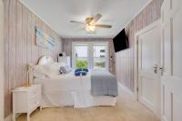默特尔比奇Beachy Keen, North Myrtle Beach beach single-family house, 150 feet to ocean! Pets welcome!的带床和吊扇的卧室