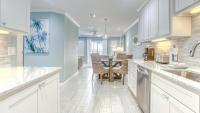 德斯坦Poolside Villas 106 - Updated beachfront condo on Holiday Isle in Destin的厨房配有白色橱柜和餐桌