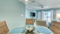 德斯坦Poolside Villas 106 - Updated beachfront condo on Holiday Isle in Destin的配有玻璃桌椅的餐厅