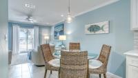 德斯坦Poolside Villas 106 - Updated beachfront condo on Holiday Isle in Destin的有桌子和椅子的餐厅