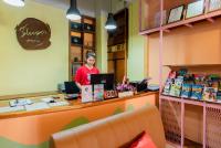 奥南海滩Sleeper Hostel的站在商店柜台后面的一名女子
