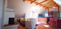 SchwanbergChalet-Südsteiermark - traumhafte Aussicht, Infinity Pool, Privatsphäre, Klima und de-luxe Ausstattung的一间带桌椅的客厅和一间厨房