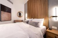 埃拉特Nathan&#39;s Suites On The Beach的卧室里有一张白色的大床和一面镜子