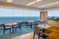 科伦坡Radisson Hotel Colombo的一间有桌椅、可欣赏海景的餐厅