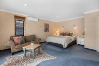 汉密尔顿Hamilton Summer Treat- 4 Bedroom with pool的一间卧室，里面有一张床、一张沙发和一张桌子