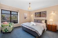 汉密尔顿Hamilton Summer Treat- 4 Bedroom with pool的卧室里有一张床和一把椅子