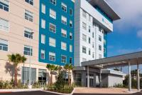 奥兰多Hyatt House Orlando Airport的一座棕榈树的办公楼