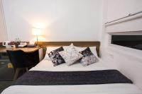 曼谷Qilombo Hostel Silom - HQ的酒店客房设有一张带书桌的床和窗户。