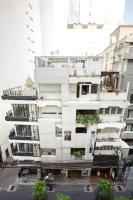 曼谷Qilombo Hostel Silom - HQ的一座高大的白色建筑,上面有植物