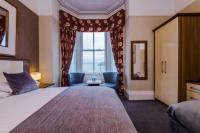 兰迪德诺Lauriston &amp; Lawton Court Hotel的有一张大床和一扇窗户的酒店房间
