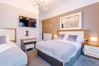 兰迪德诺Lauriston &amp; Lawton Court Hotel的有两张床和一张书桌的酒店房间