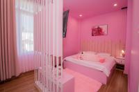 大叻Suri Homestay的粉红色的卧室设有床和窗户