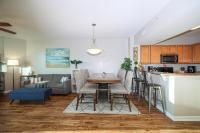德斯坦Marvelous 9th Floor Condo Gulf, Pool &amp; Sunset View的配有桌椅的厨房和客厅