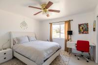 约书亚树Electroliquid&#39;s Casa Pueblo Joshua Tree的一间卧室配有一张床、一张桌子和吊扇