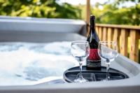 鸽子谷Creekside Cottage*Hot Tub*Entire Home-Pigeon Forge的托盘上放有一瓶葡萄酒和两杯酒杯