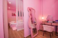 大叻Suri Homestay的粉红色的房间,配有梳妆台和镜子